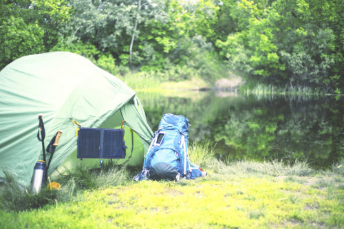 Camping on the river bank. The solar panel hangs on the tent.