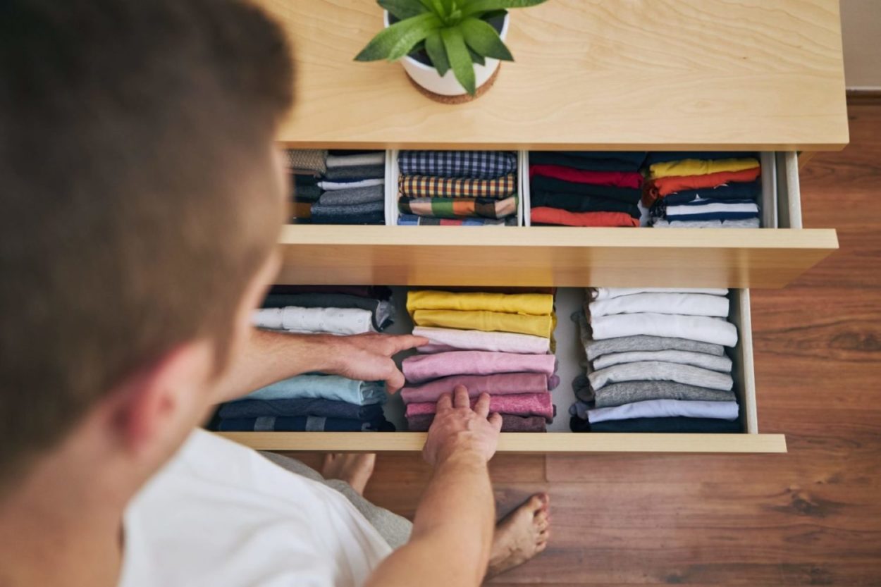 Man going through his closet is decluttering for good health
