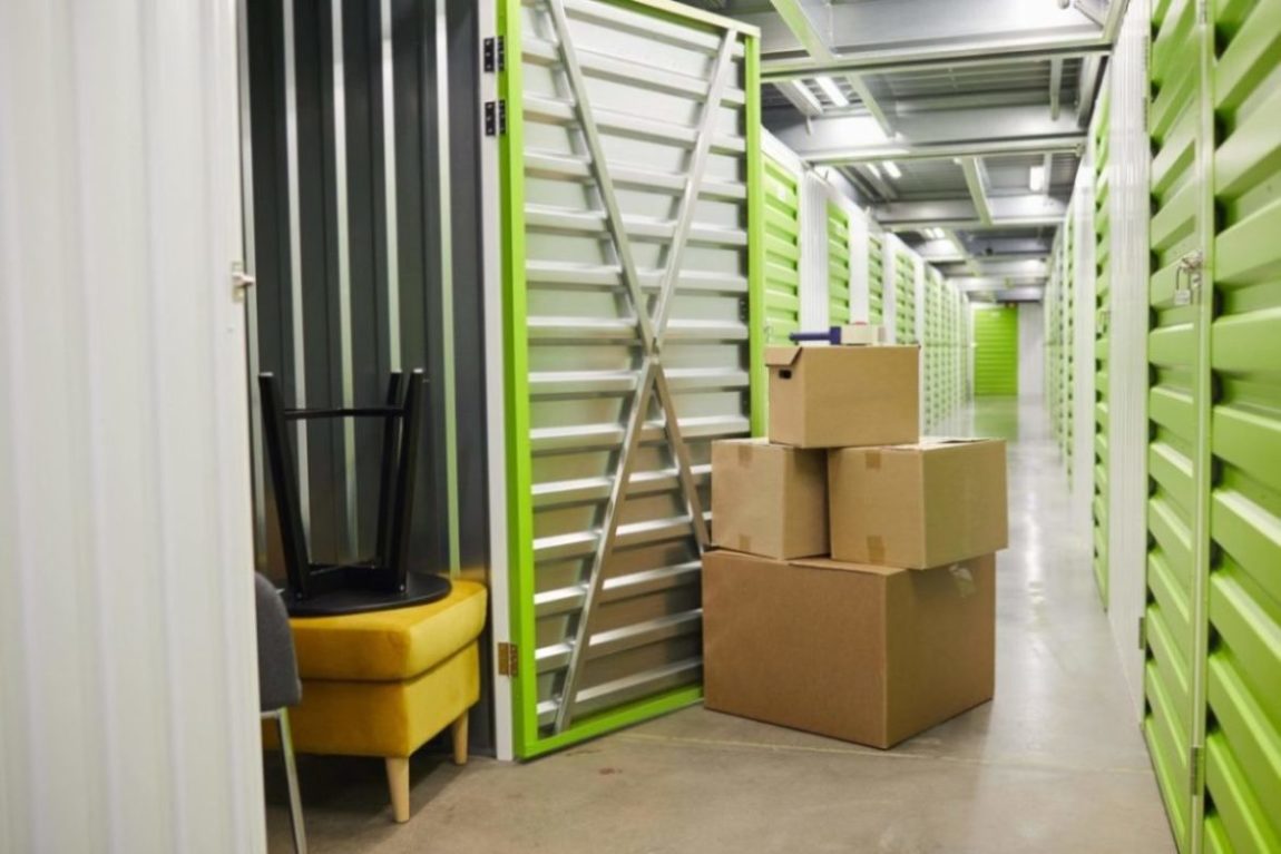 An open storage unit with boxes sitting outside.